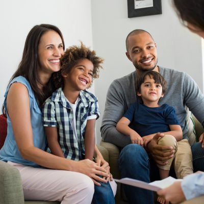 Diverse family of 4 talking with councelor at home