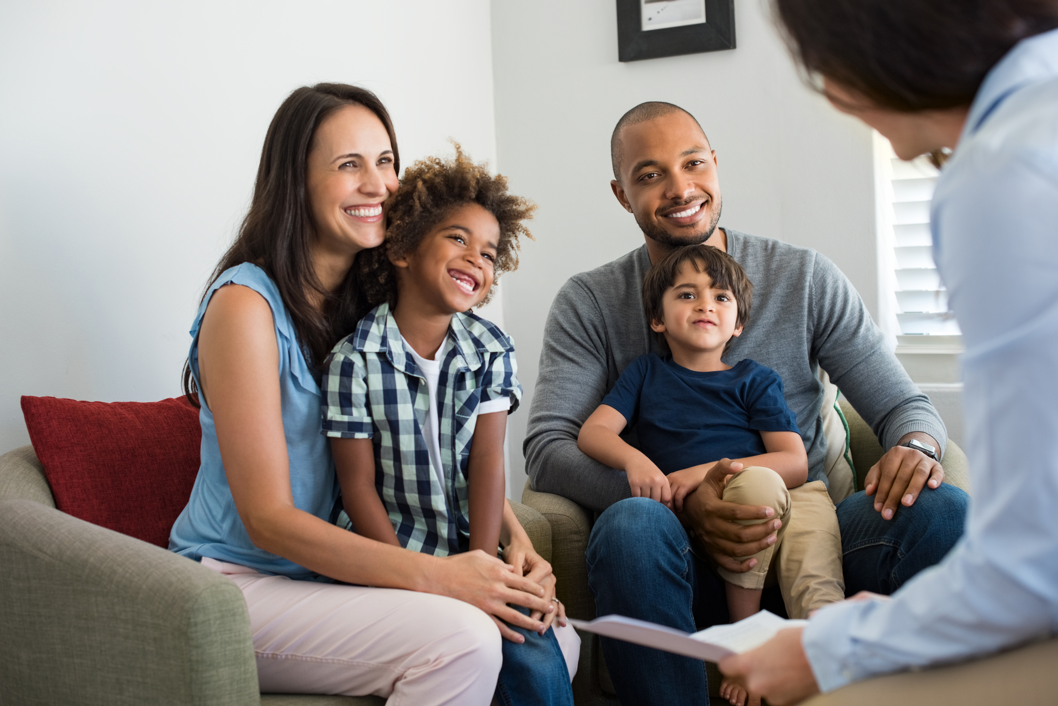 Diverse family of 4 talking with councelor at home